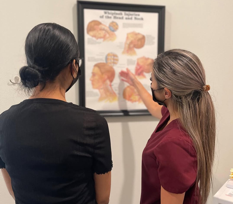 Chiropractor performing spinal adjustment on patient with whiplash