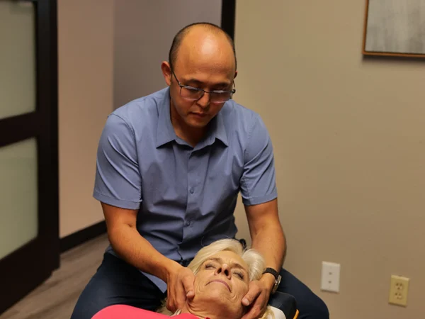 Chiropractor performing spinal adjustment on patient with whiplash